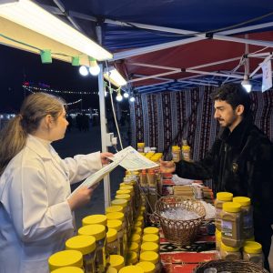 طالبة من قسم الأحياء المجهرية الطبية توزع تقويم رمضان وتجري نشاطاً للتوعية بسلامة الغذاء في سوق شارع أربيل